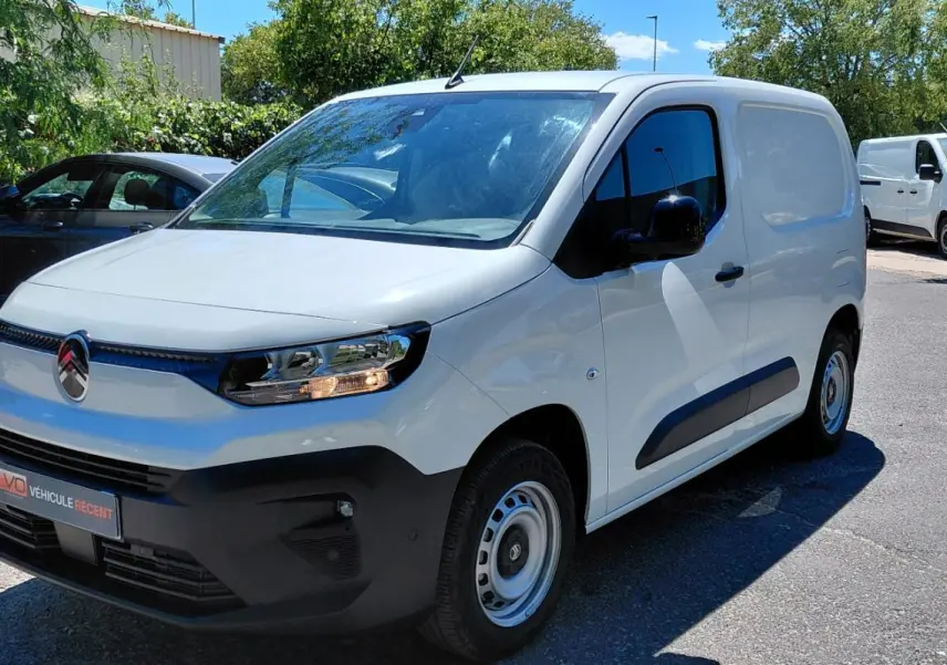 Citroën Berlingo blanc en 3/4 avant droit, fourgon compact avec pare-chocs noirs et jantes acier 15 pouces.