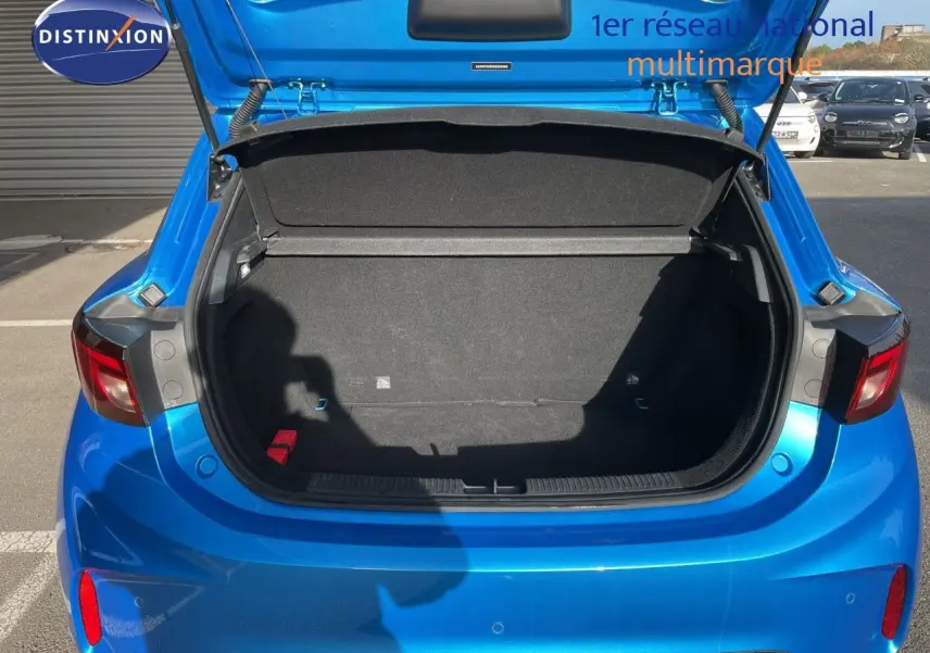 Coffre ouvert vu de l'arrière d'une MG3 1.5L Hybrid+ 2024 en bleu Como Metal, avec intérieur de coffre noir vide.