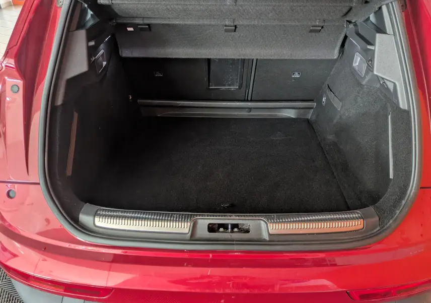 Vue plongeante sur le coffre ouvert d’un DS7 rouge 2019 avec attelage, soulignant l’espace de chargement vide.