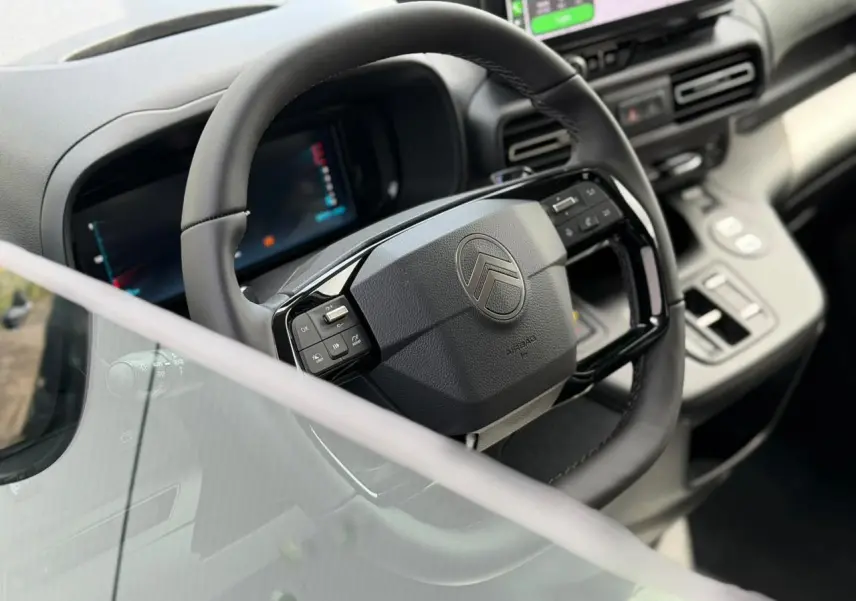 Vue rapprochée du volant cuir multifonctions et du combiné numérique du tableau de bord intérieur du Citroën Berlingo Multispace 2026.