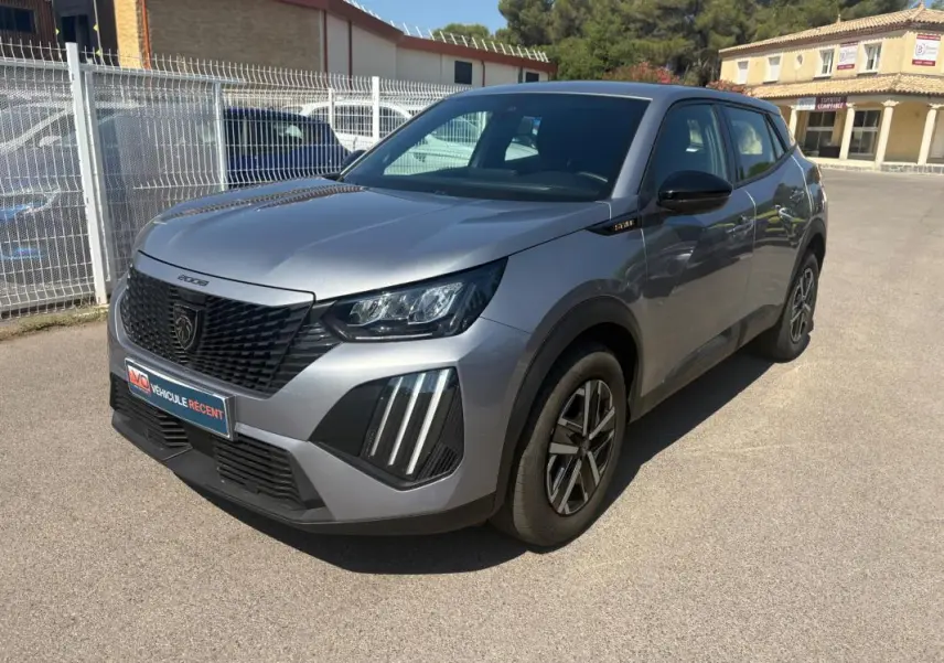 Peugeot 2008 Hybrid gris en 3/4 avant droit, avec calandre noire et jantes 16 pouces visibles.