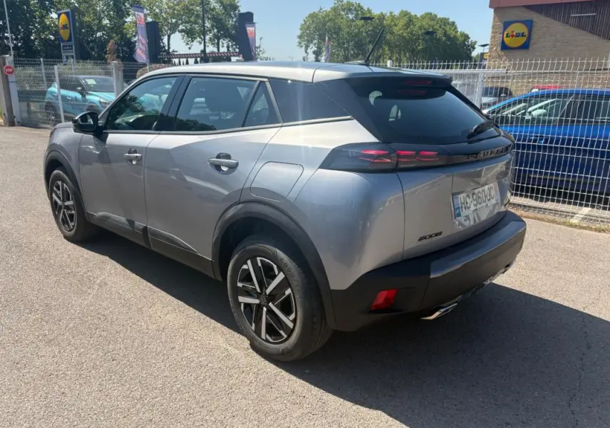 Peugeot 2008 Hybrid 145 gris en 3/4 arrière droit, jantes 16 pouces et feux arrière LED distinctifs.