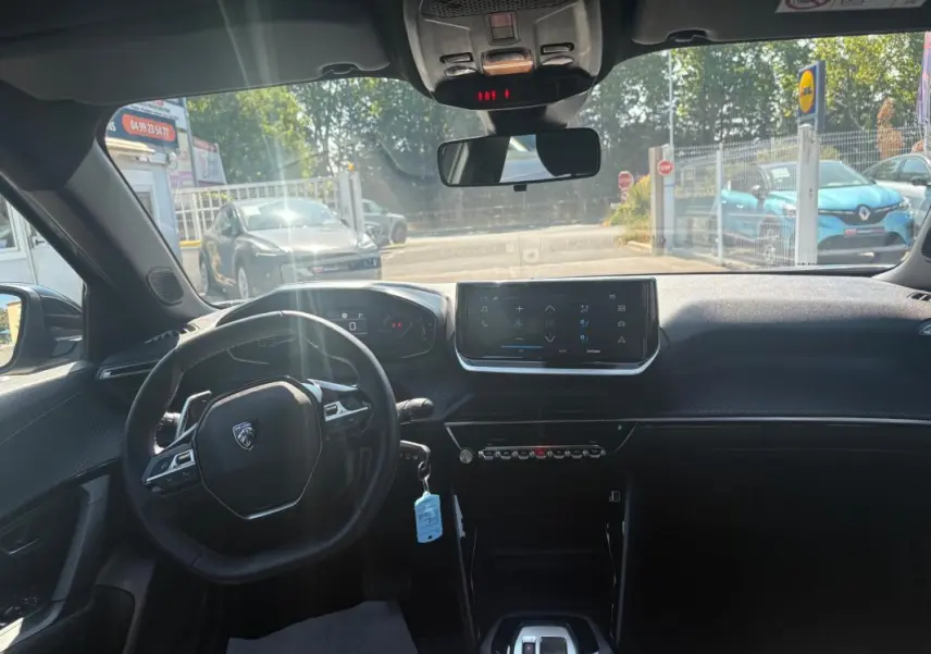 Vue intérieure avant du Peugeot 2008 Hybrid 145 Style gris 2025 avec écran tactile et cockpit numérique.