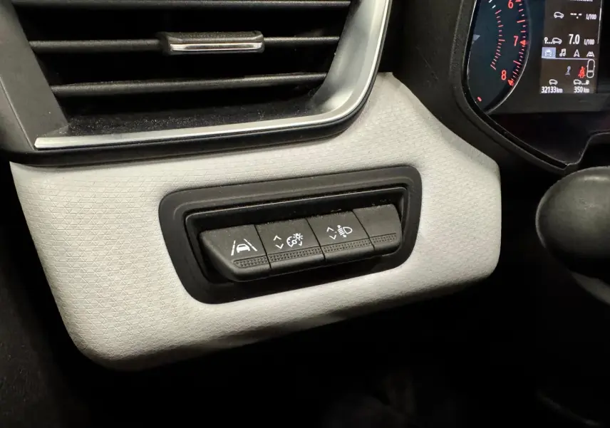 Vue intérieure du tableau de bord côté gauche de la Renault Clio V gris aluminium, avec commandes d'aide à la conduite et éclairage.