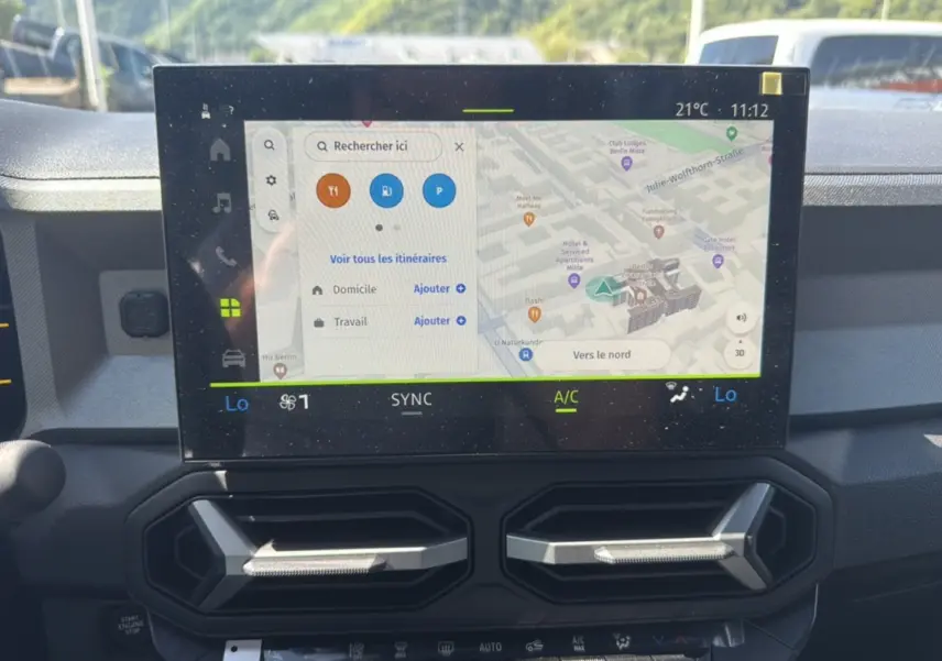 Écran tactile central du tableau de bord du Dacia Bigster Hybrid 150, affichant la navigation GPS en vue rapprochée.