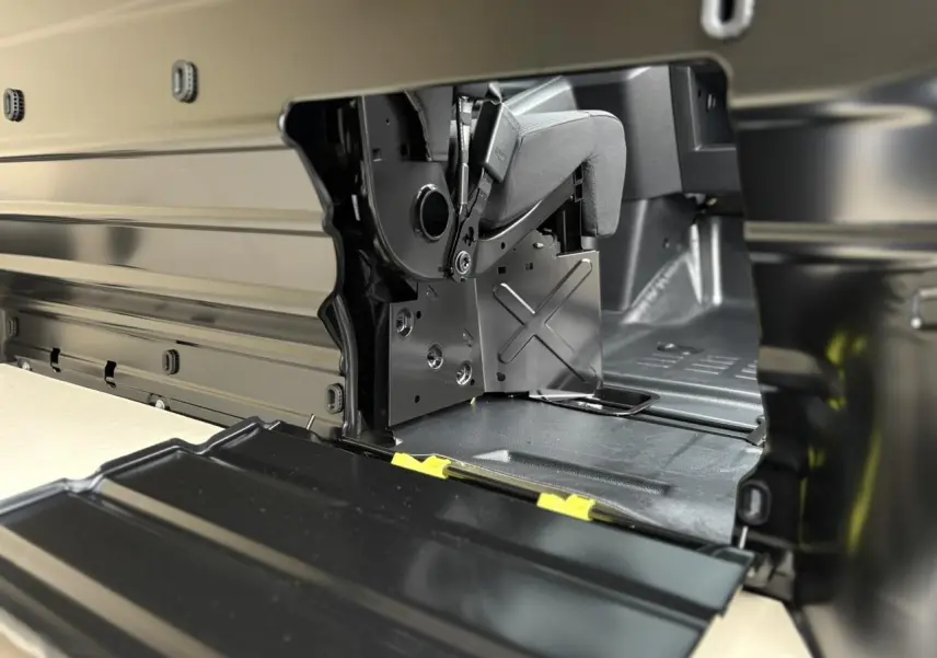 Détail intérieur côté droit du Peugeot Expert Fourgon blanc, montrant la trappe de charge longue et la banquette relevable.