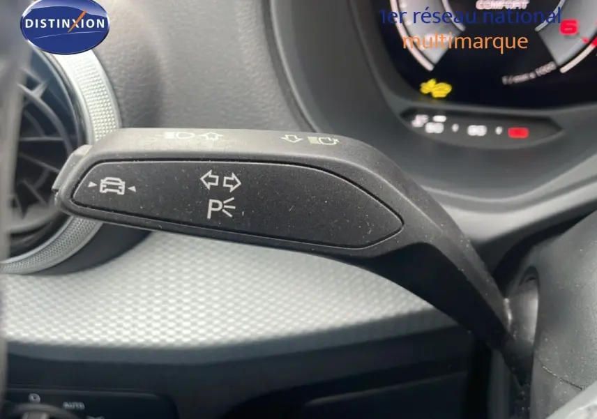 Gros plan sur la commande de clignotant à gauche dans l’habitacle d’un Audi Q2 noir mito metal 2025.