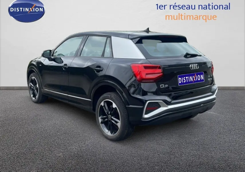 Audi Q2 noir mito metal vue 3/4 arrière droit, avec jantes noires et détails S-Line visibles.