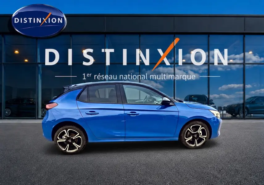 Opel Corsa 1.2 turbo 100 GS bleu vue de profil côté gauche devant une vitrine Distinxion.