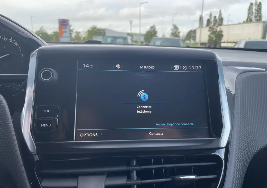 Écran tactile central du Peugeot 2008 gris 2019 affichant la connexion Bluetooth avec commandes autour et tableau de bord partiel.