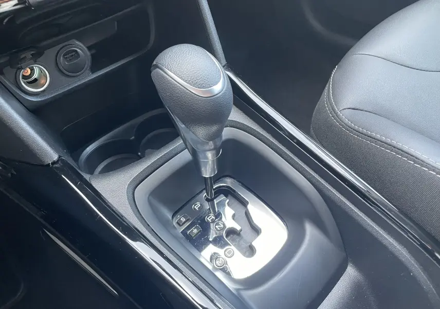Le levier de vitesses automatique de la Peugeot 2008 1.2 110 ALLURE EAT6 en gros plan, avec sellerie noire et console brillante.