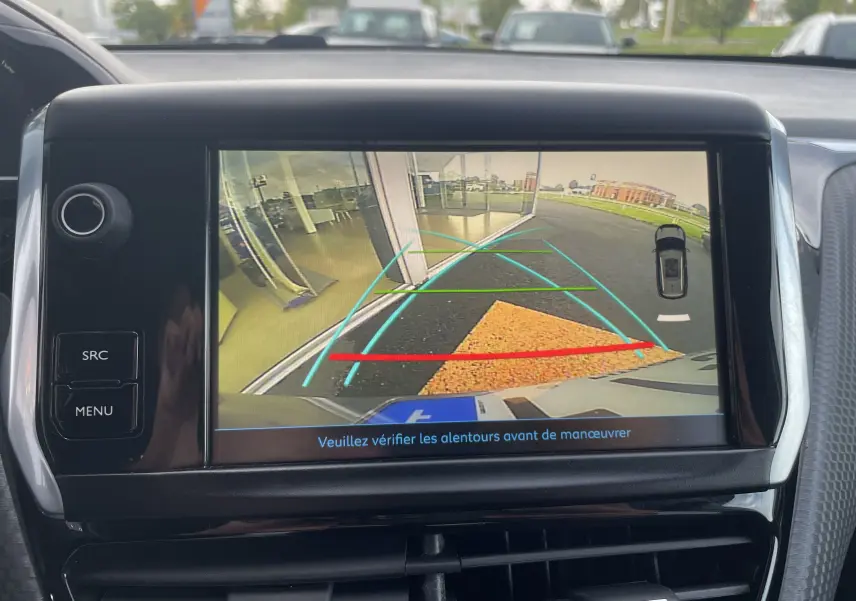 Écran de caméra de recul du Peugeot 2008 gris, montrant les lignes d'aide au stationnement et l'arrière du véhicule.