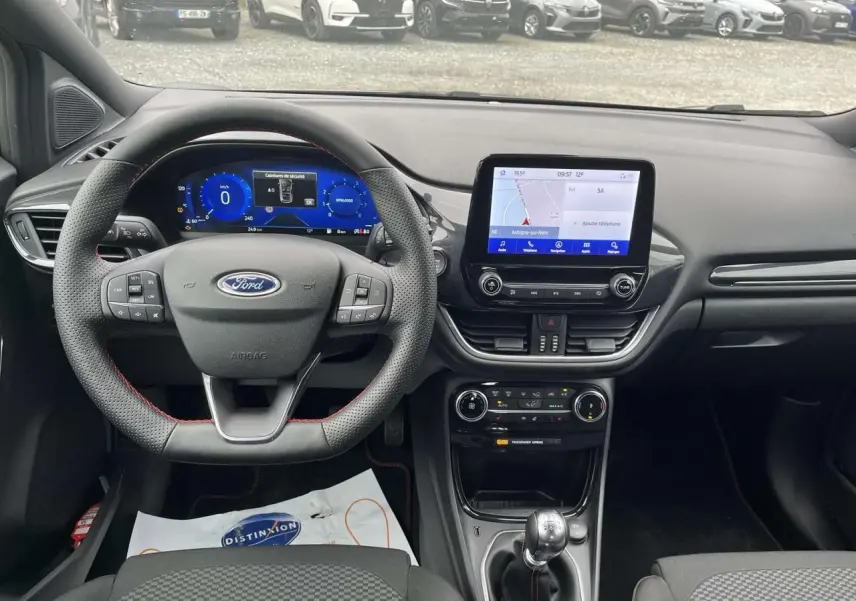 Vue intérieure du tableau de bord et volant Ford Puma 2023 avec écran tactile et boîte manuelle, ambiance noire moderne.