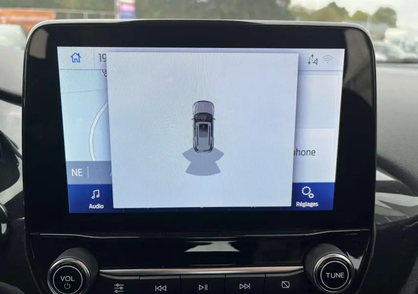 Écran tactile central du Ford Puma 2023 montrant l'assistance au stationnement avec vue du véhicule en plan dessus.