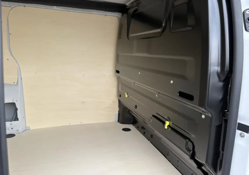 Vue intérieure de la zone de chargement du Peugeot Expert Fourgon blanc Icy, avec parois et plancher en bois clair.