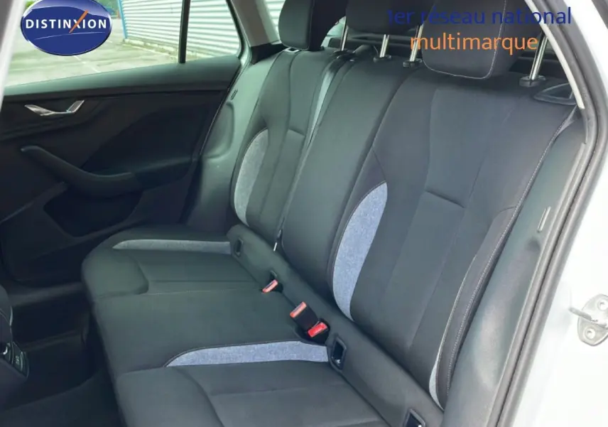 Vue intérieure côté droit sur la banquette arrière en tissu gris et noir du Skoda Scala blanc glacier 2025.