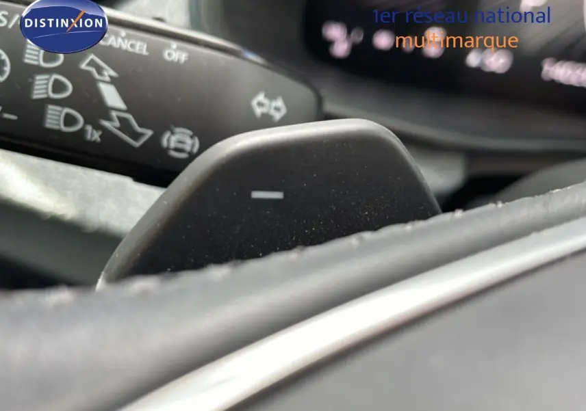 Gros plan sur la palette de changement de vitesse côté droit du volant d’une Skoda Scala blanc glacier, intérieur gris noir.