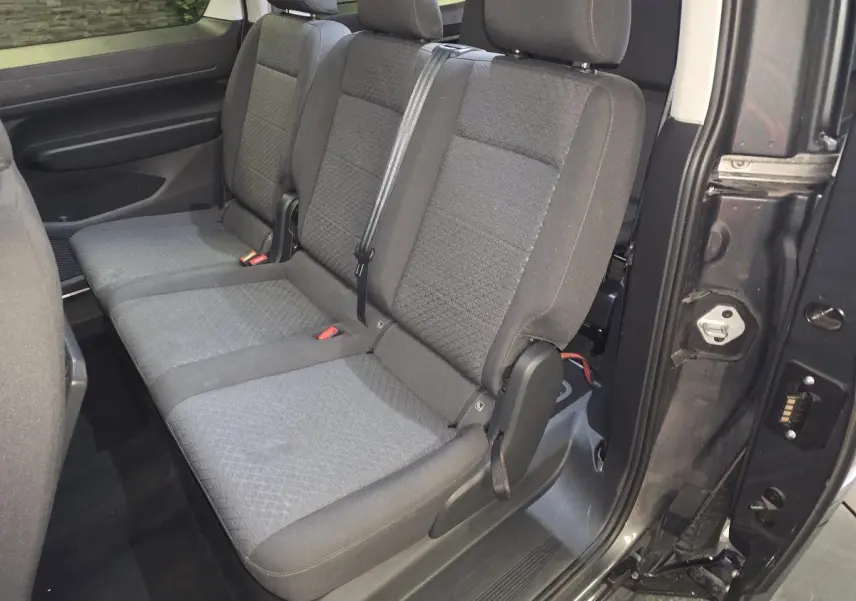 Vue intérieure côté droit sur la banquette arrière grise du Ford Transit Connect Tourneo 2023 avec porte coulissante ouverte.