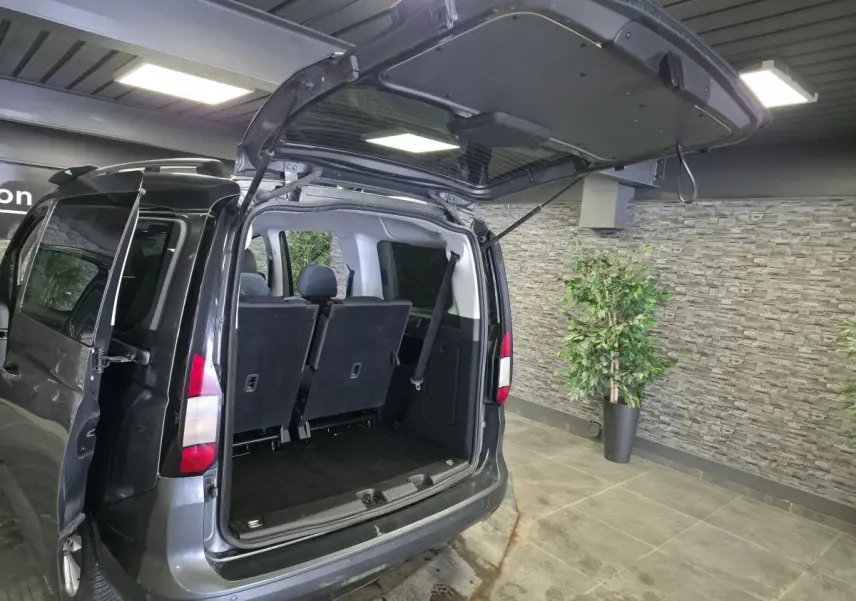 Vue arrière ouverte du Ford Transit Connect gris métallisé montrant les sièges arrière et le coffre vide.