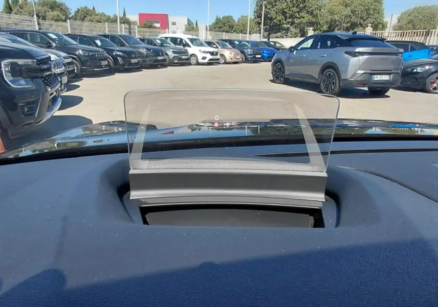 Affichage tête haute transparent sur le tableau de bord d’une Citroën C4 X noire, vue depuis l’intérieur vers l’avant.