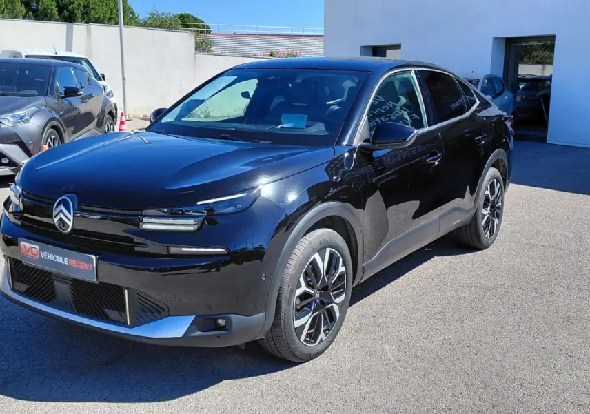 Citroën C4 X hybride noir vue 3/4 avant droit, avec jantes alliage 17 pouces et toit ouvrant panoramique.