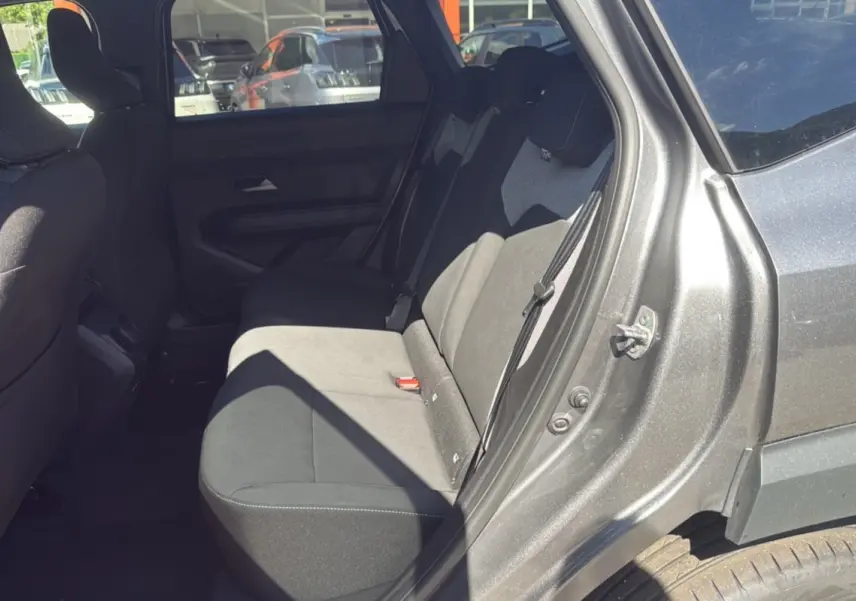 Vue intérieure côté arrière droit du Dacia Bigster gris schiste, montrant la banquette arrière et la portière ouverte.