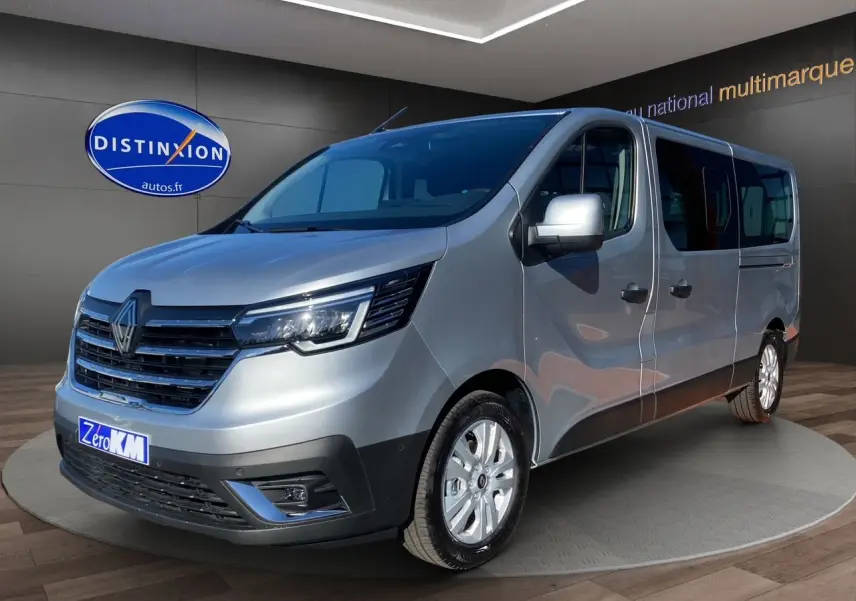 Renault Trafic Combi gris Highland en 3/4 avant droit avec portes latérales vitrées et jantes alliage 17 pouces.