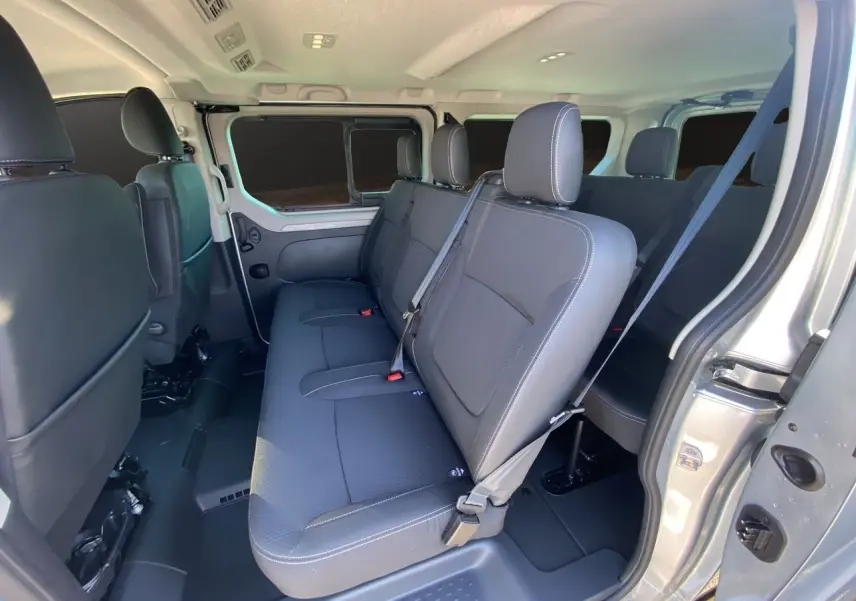 Intérieur du Renault Trafic Combi L2 Grand Techno 8 places, vue côté droit sur les sièges tissu noir et ceinture de sécurité.