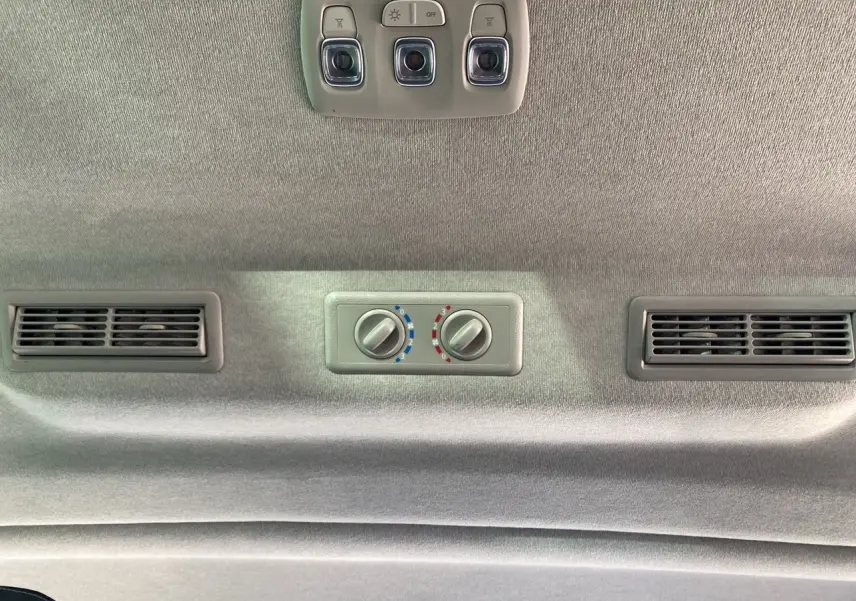 Plafond intérieur gris avec commandes de climatisation arrière et éclairage dans un Renault Trafic Combi gris Highland 2025.