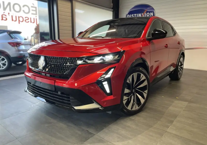 Renault Rafale rouge à toit noir en 3/4 avant droit, avec calandre 3D et feux LED distinctifs allumés.