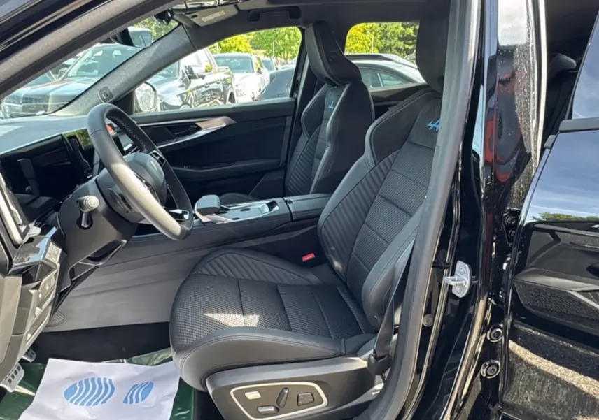 Vue intérieure côté conducteur du Renault Austral noir étoilé, sièges sport semi-alcantara avec logo Alpine bleu brodé.