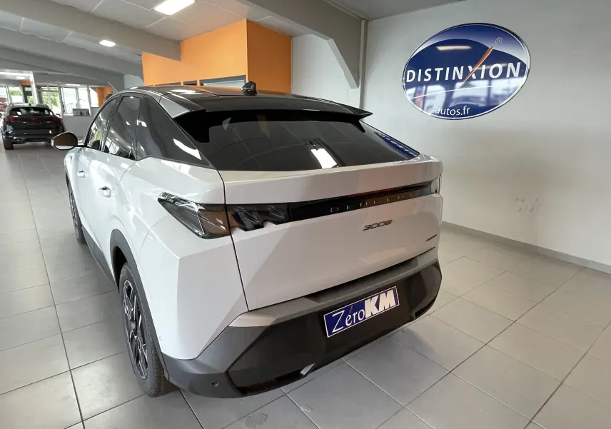 Vue 3/4 arrière droite du Peugeot 3008 blanc Okenite avec toit noir et feux arrière full LED en intérieur showroom.