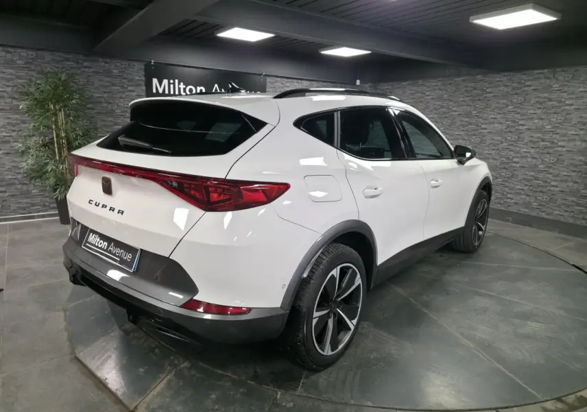 Vue 3/4 arrière droite du CUPRA Formentor blanc avec bandeau LED arrière et jantes alliage 18 pouces.