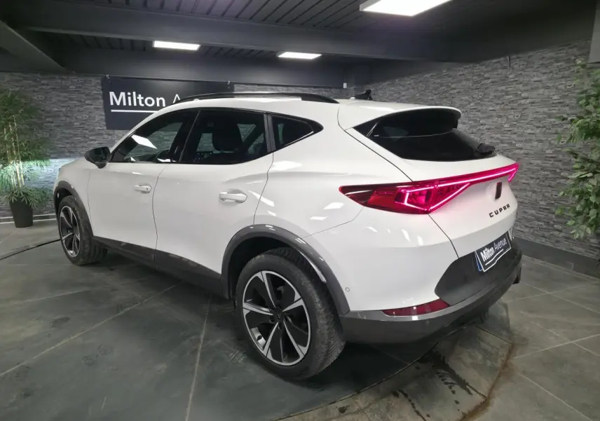 Vue 3/4 arrière droite du CUPRA Formentor blanc Nevada 2024 avec bandeau lumineux arrière et jantes alliage 18 pouces.