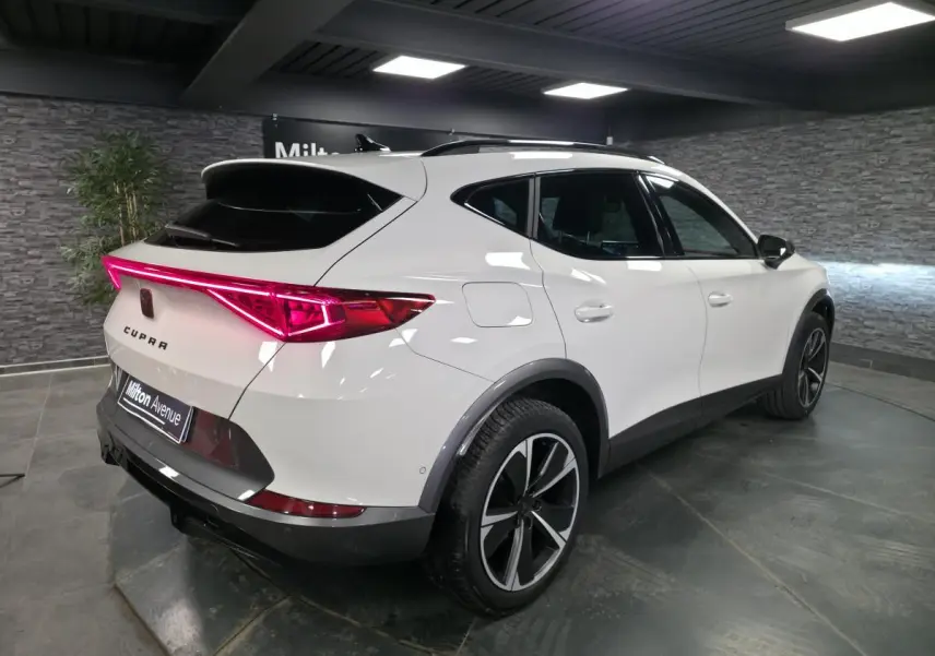 Vue 3/4 arrière droite du CUPRA Formentor blanc avec bandeau LED arrière Infinite Light et jantes alliage 18 pouces.
