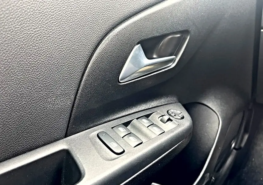 Gros plan sur la commande des vitres électriques et le verrouillage centralisé côté conducteur de l’Opel Corsa 2025.