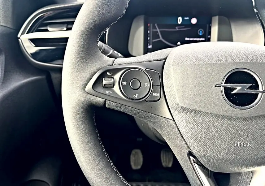 Gros plan sur le volant multifonction noir de l'Opel Corsa 2025 avec tableau de bord numérique en arrière-plan.