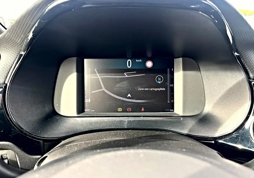 Vue rapprochée du tableau de bord numérique de l'Opel Corsa bleu 2025, affichant la navigation et 0 km/h.