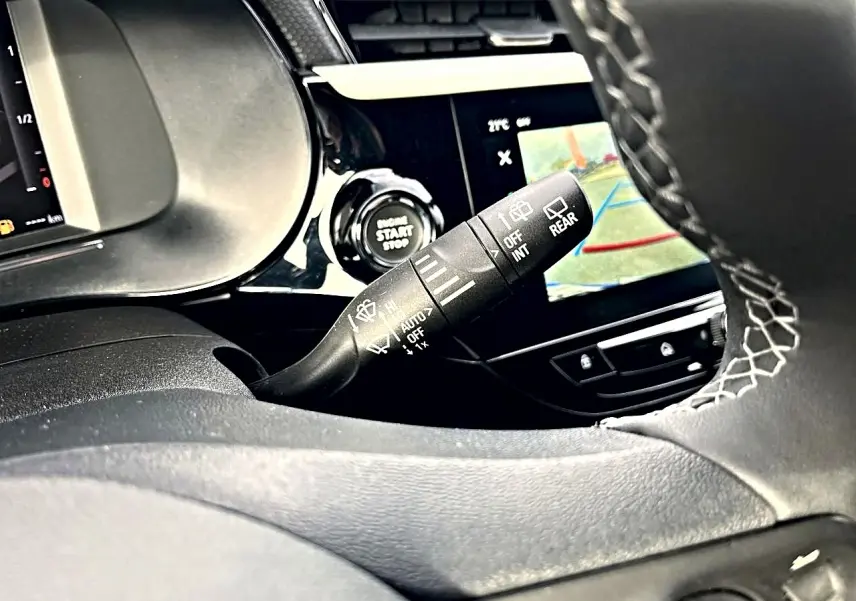 Gros plan sur la commande d’essuie-glace à gauche du volant dans l’habitacle noir de l’Opel Corsa 2025.