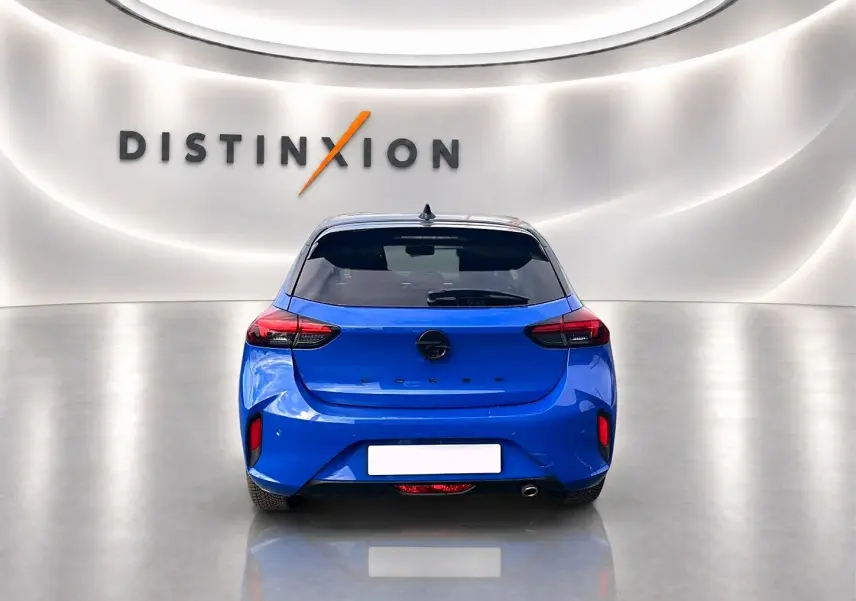 Vue arrière d'une Opel Corsa 1.2 turbo bleu vif, avec feux arrière LED et échappement à droite, en studio lumineux.