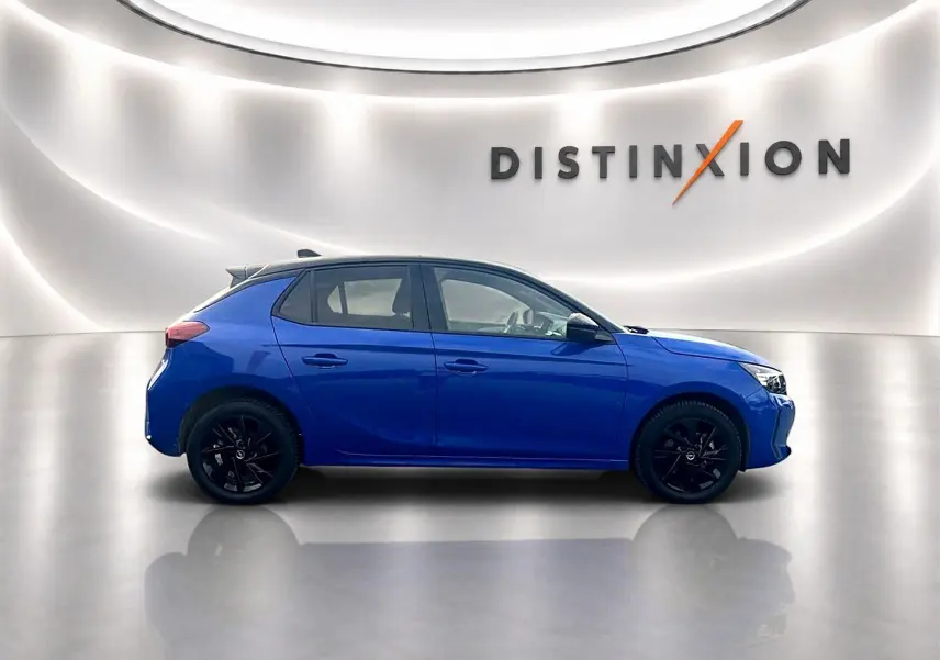 Profil droit d’une Opel Corsa bleu 2025 avec jantes noires, dans un studio lumineux marqué Distinxion.