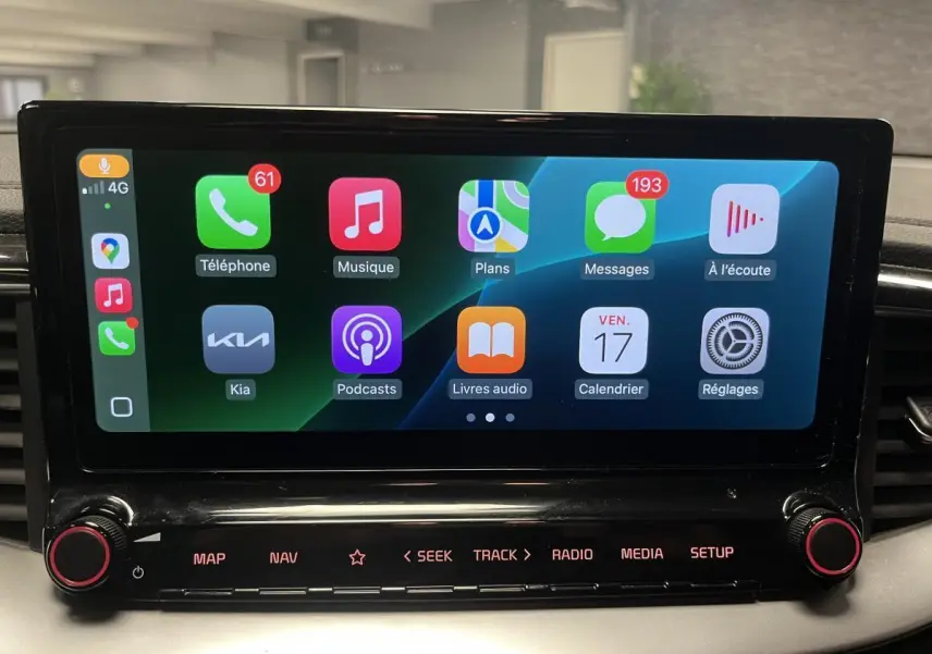 Écran tactile central 10,25" de la Kia Ceed 2023 affichant Apple CarPlay avec commandes sous l'écran noir laqué.