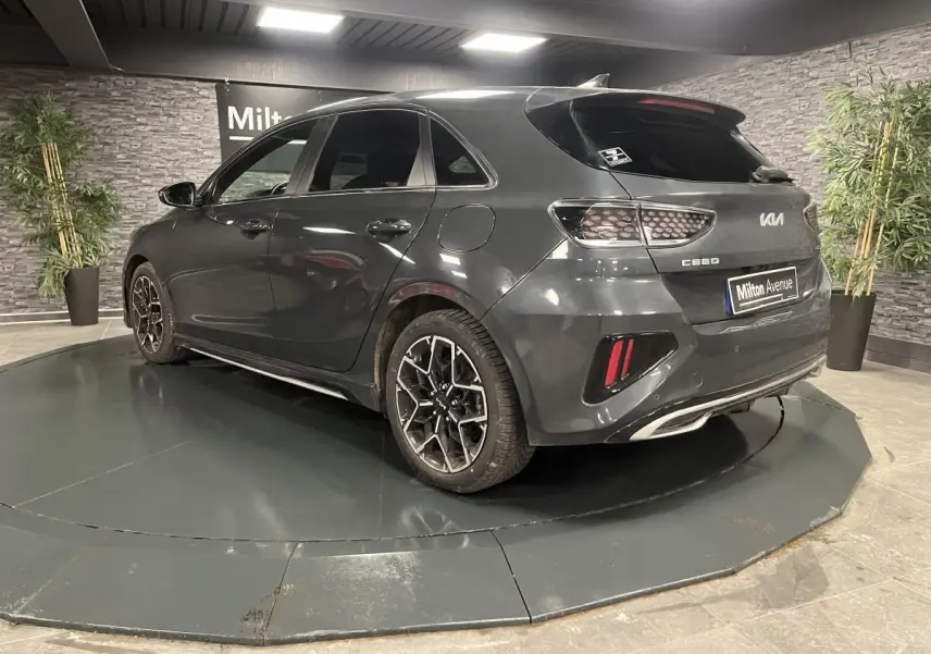 Vue 3/4 arrière droite d'une KIA Ceed gris métallisé avec jantes alliage et feux arrière en nid d'abeille.