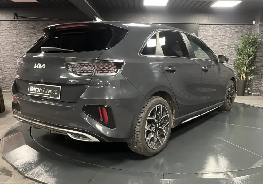 Vue 3/4 arrière droite d'une Kia Ceed gris métallisé GT Line Premium avec jantes alliage et becquet arrière.