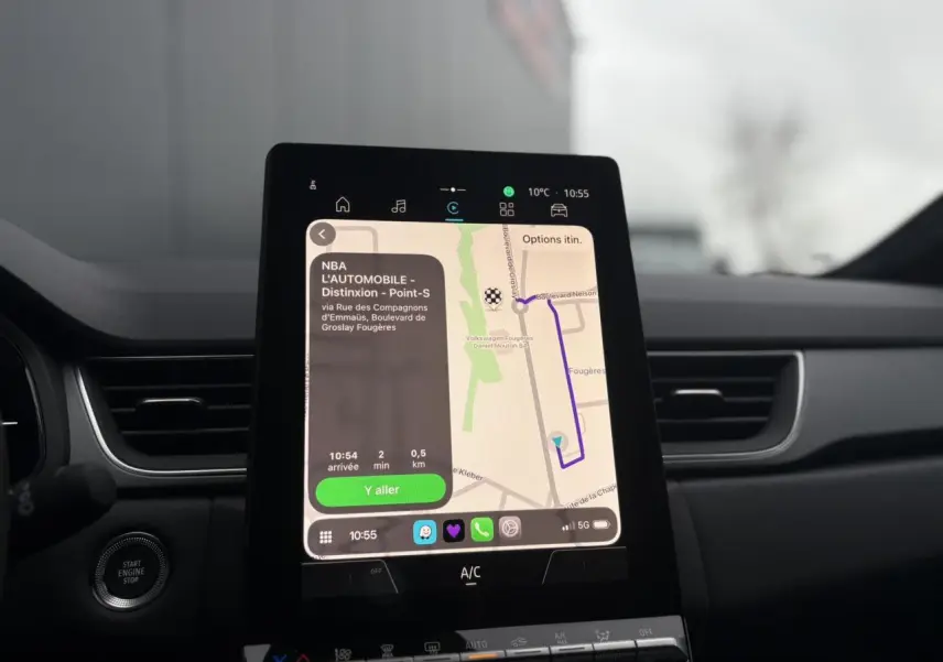 Vue intérieure centrée sur l'écran tactile vertical du système multimédia du Renault Captur 2025, tableau de bord noir.