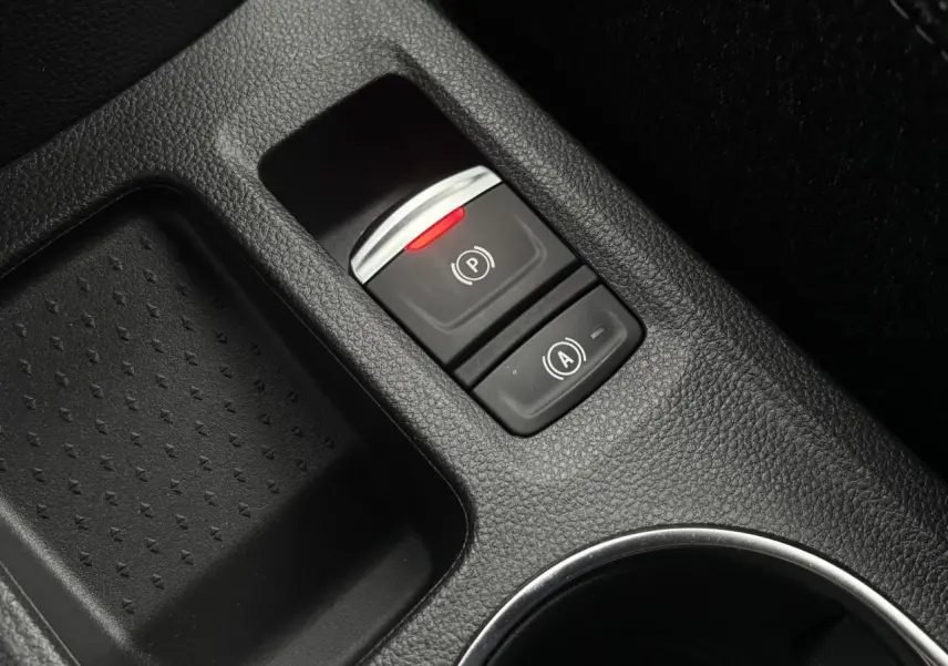 Gros plan sur la console centrale noire du Renault Captur 2025, avec bouton frein de parking électrique et fonction Auto-Hold.