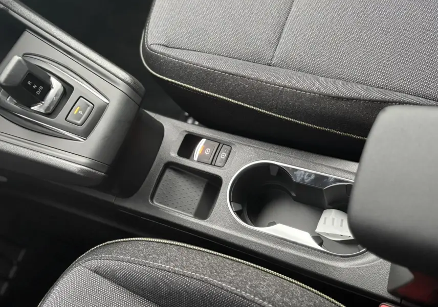 Vue rapprochée de la console centrale noire avec levier de vitesses et porte-gobelets du Renault Captur gris Cassiopée 2025.
