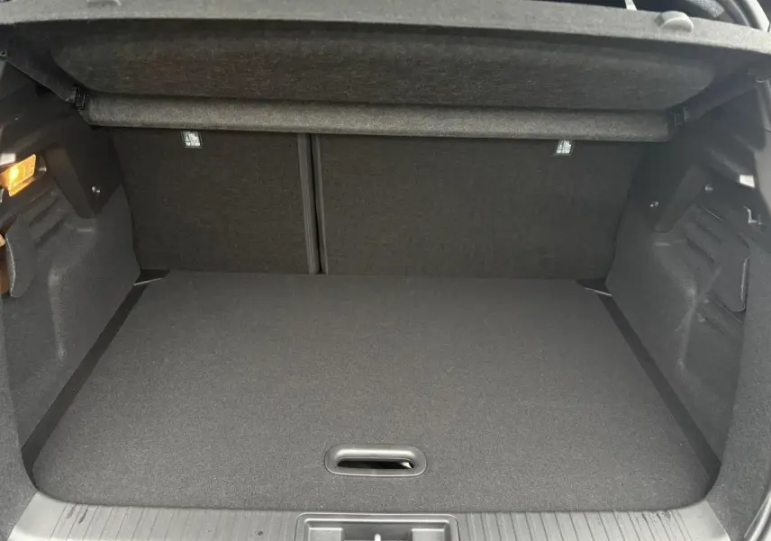 Vue intérieure du coffre spacieux et propre du Renault Captur 2025, avec plancher de coffre mobile et éclairage latéral.