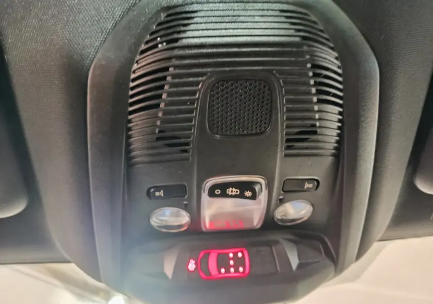 Vue en gros plan du plafonnier intérieur noir avec commandes d’éclairage et alerte de ceinture du Peugeot 5008 gris clair 2023.