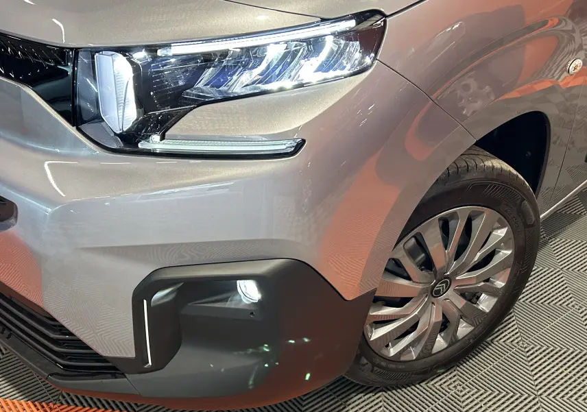 Gros plan sur l'avant droit gris acier du Citroën Berlingo Multispace III Ph.2 avec phare LED et jante alliage distinctive.